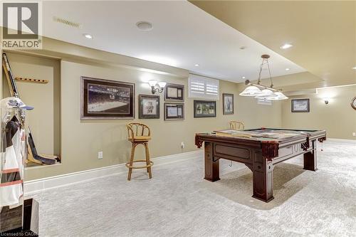 This spacious room features light-colored carpeting, recessed lighting, and a pool table with an overhead light fixture - 4278 Clubview Drive, Burlington, ON - Indoor Photo Showing Other Room