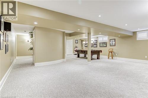 Spacious room featuring light-colored carpet, recessed lighting, and windows with white plantation shutters - 4278 Clubview Drive, Burlington, ON - Indoor Photo Showing Basement