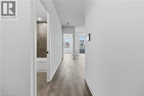 The property features neutral-toned walls, wood-style flooring, and recessed lighting in the hallway - 4878 Powers Common Unit# 224, Burlington, ON - Indoor Photo Showing Other Room