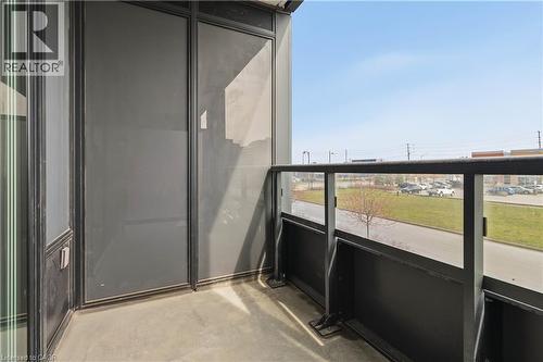 The property features a balcony with a glass and metal railing, offering views of the surrounding area - 4878 Powers Common Unit# 224, Burlington, ON - Outdoor With Balcony With Exterior