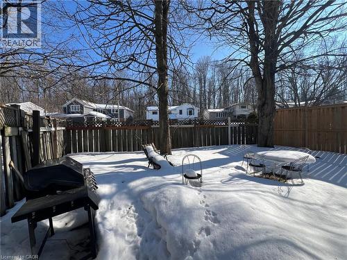 The property features a fenced yard with mature trees and a snow-covered lawn - 134 Greenbrier Drive, Waterloo, ON 