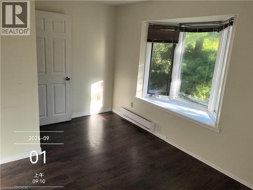 This room features dark-toned flooring, light-colored walls, and a multi-pane bay window with blinds - 134 Greenbrier Drive, Waterloo, ON 