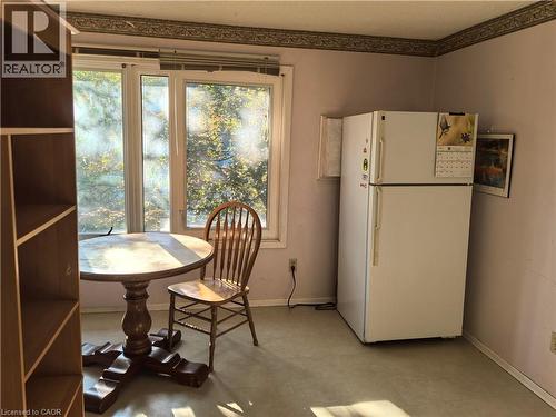 This bright interior space features large windows, a white refrigerator, and light-colored flooring - 134 Greenbrier Drive, Waterloo, ON 