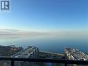 Expansive water views from a balcony with a glass railing, overlooking nearby buildings and a clear horizon - 385 Winston Road Unit# 1607, Grimsby, ON  - Outdoor With Body Of Water With View 