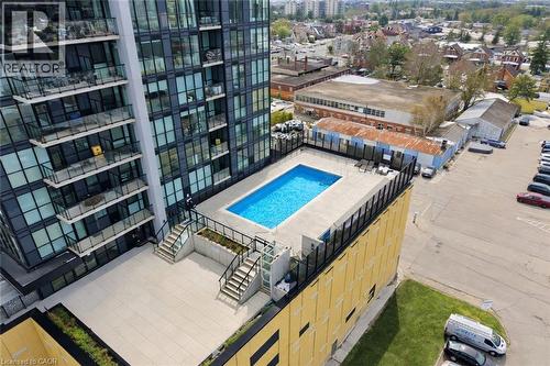The property features an outdoor swimming pool with surrounding patio space, providing an inviting area for recreation - 104 Garment Street Unit# 1206, Kitchener, ON - Outdoor