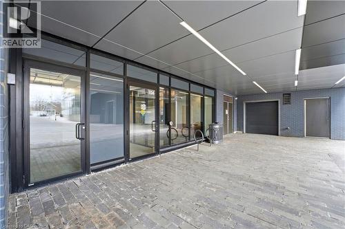 This property features a contemporary exterior with large glass storefronts, a covered entrance, and a paved brick courtyard - 104 Garment Street Unit# 1206, Kitchener, ON - Indoor Photo Showing Other Room