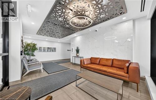 The welcoming common area features a patterned ceiling detail with recessed lighting, tile flooring, and a decorative wall accent - 104 Garment Street Unit# 1206, Kitchener, ON - Indoor