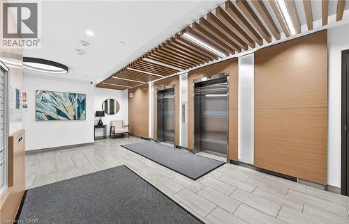 The property features a lobby with light-colored tile flooring and two stainless steel elevators - 104 Garment Street Unit# 1206, Kitchener, ON - Indoor Photo Showing Other Room