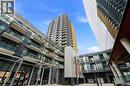 The property features contemporary architecture with a blend of glass and paneling, private balconies, and a clear blue sky overhead - 104 Garment Street Unit# 1206, Kitchener, ON  - Outdoor With Balcony 