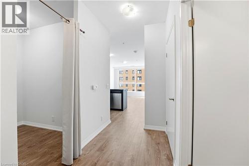 The property features light-colored walls, wood flooring, and white trim throughout the hallway - 104 Garment Street Unit# 1206, Kitchener, ON - Indoor Photo Showing Other Room