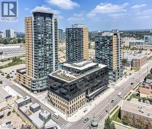 This aerial view showcases a collection of modern high-rise buildings featuring extensive glass facades and balconies - 108 Garment Street S Unit# 708, Kitchener, ON - Outdoor