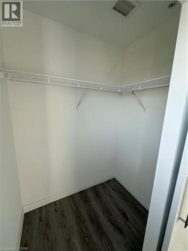 This closet features neutral white walls, wire shelving, and wood-look flooring - 108 Garment Street S Unit# 708, Kitchener, ON - Indoor With Storage