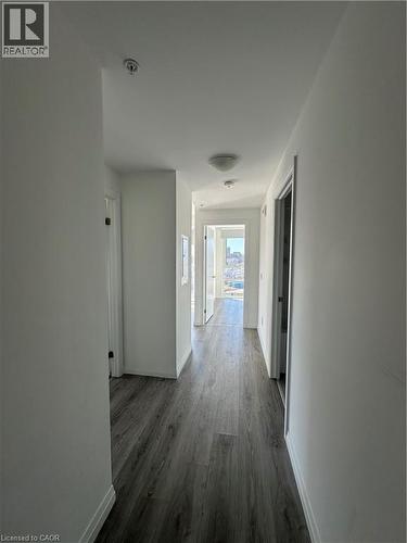 Hallway featuring modern grey wood-style flooring, white walls, and flush-mount ceiling lights - 108 Garment Street S Unit# 708, Kitchener, ON - Indoor Photo Showing Other Room