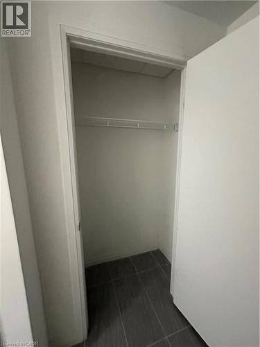This property features a closet with a wire shelf and dark tiled flooring - 108 Garment Street S Unit# 708, Kitchener, ON - Indoor