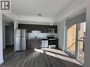 This property features a kitchen with stainless steel appliances, dark wood-style cabinetry, and a white subway tile backsplash - 108 Garment Street S Unit# 708, Kitchener, ON  - Indoor Photo Showing Kitchen 