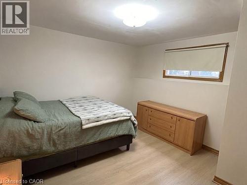 Room featuring light wood-finish flooring, a window with wood trim, and a flush-mount ceiling light fixture - 70 Bechtel Drive, Kitchener, ON - Indoor Photo Showing Bedroom