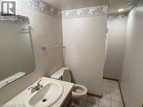 Bathroom featuring a vanity with an integrated sink, a wall-mounted mirror, white ceramic tile flooring, and a recessed ceiling light - 70 Bechtel Drive, Kitchener, ON - Indoor Photo Showing Bathroom