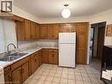 Bright kitchen featuring wood cabinetry, white countertops, a double basin stainless steel sink with a high-arc faucet, and a large window - 70 Bechtel Drive, Kitchener, ON  - Indoor Photo Showing Kitchen With Double Sink 