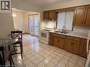 Kitchen featuring tile flooring, wood-finish cabinetry, a double basin sink, and a white electric range - 70 Bechtel Drive, Kitchener, ON  - Indoor Photo Showing Kitchen With Double Sink 