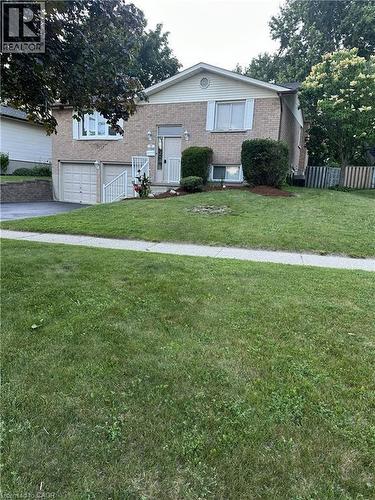 The property features a brick exterior with white siding, an attached garage, and a well-maintained lawn - 70 Bechtel Drive, Kitchener, ON - Outdoor