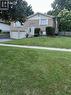 The property features a brick exterior with white siding, an attached garage, and a well-maintained lawn - 70 Bechtel Drive, Kitchener, ON  - Outdoor 