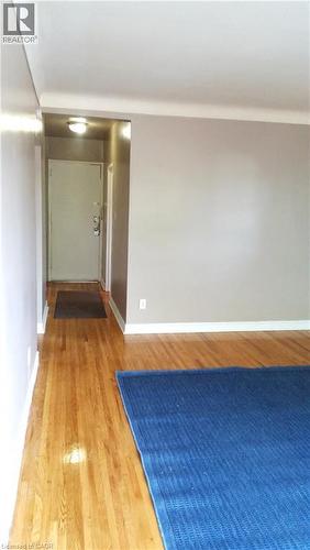 The interior features hardwood flooring, light-colored walls, and white baseboards - 981 Mohawk Road E, Hamilton, ON - Indoor Photo Showing Other Room