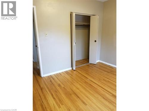 This room features hardwood floors and a closet with bi-fold doors - 981 Mohawk Road E, Hamilton, ON - Indoor Photo Showing Other Room