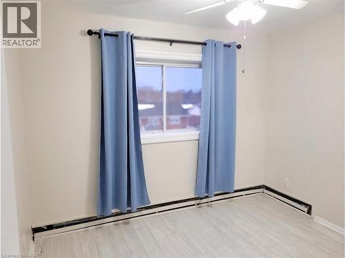 The room features light-colored walls, a window with curtains, and a ceiling fan with integrated lighting - 981 Mohawk Road E, Hamilton, ON - Indoor Photo Showing Other Room