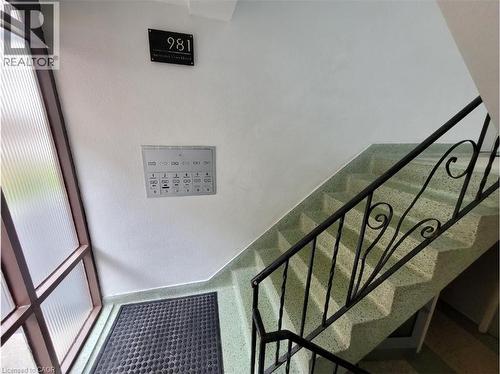 The property features a staircase with a black metal railing and light green speckled steps - 981 Mohawk Road E, Hamilton, ON - Indoor Photo Showing Other Room