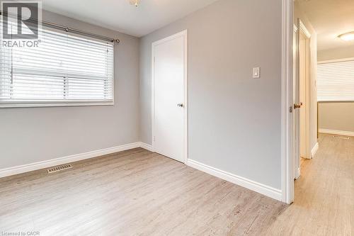 This room features light-colored walls, light wood-style flooring, and a window with horizontal blinds - 687 Britannia Avenue, Hamilton, ON - Indoor Photo Showing Other Room
