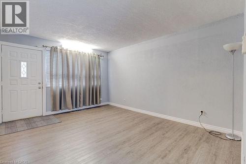 The entryway features a white paneled door with a decorative window, light-colored flooring, and light-toned walls - 687 Britannia Avenue, Hamilton, ON - Indoor Photo Showing Other Room