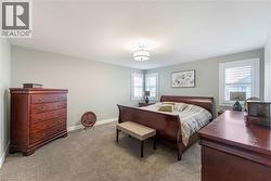 The room features light gray walls, a textured ceiling, and gray carpeted flooring - 
