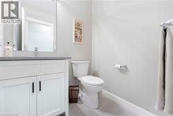 This bathroom features a contemporary vanity with a gray countertop, a sleek faucet, and a toilet - 