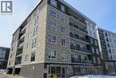 The property features a modern building with a facade of stone and dark paneling, complemented by a light-colored upper section - 275 Larch Street Unit# 108, Waterloo, ON  - Outdoor With Facade 