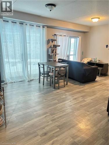 The property features light-toned wood-look flooring and light-colored walls - 275 Larch Street Unit# 108, Waterloo, ON - Indoor Photo Showing Other Room