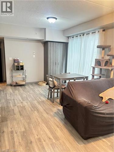 This space features wood-style flooring and light-colored walls - 275 Larch Street Unit# 108, Waterloo, ON - Indoor