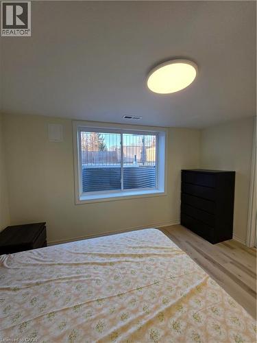 This room features light-colored walls, a window with an exterior view, and light-toned flooring - 62 Richwill Road Unit# Lower, Hamilton, ON - Indoor Photo Showing Bedroom