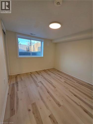 This room features light-toned hardwood flooring, a window offering natural light, and recessed lighting - 62 Richwill Road Unit# Lower, Hamilton, ON - Indoor Photo Showing Other Room