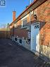 The property features a brick exterior with a chimney, a white exterior door, and a paved surface - 62 Richwill Road Unit# Lower, Hamilton, ON  - Outdoor With Exterior 