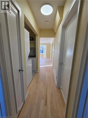Hallway featuring light-toned wood flooring, a ceiling-mounted light fixture, and white doors with silver-toned hardware - 62 Richwill Road Unit# Upper, Hamilton, ON - Indoor Photo Showing Other Room