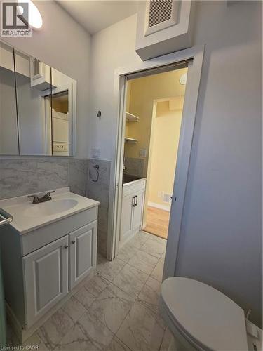 Bathroom featuring a white vanity with a sink and cabinets, a toilet, and tiled floors - 62 Richwill Road Unit# Upper, Hamilton, ON - Indoor Photo Showing Bathroom
