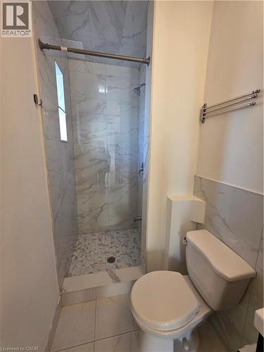 The bathroom features a walk-in shower with marble-patterned wall tiles and a mosaic-tiled floor - 62 Richwill Road Unit# Upper, Hamilton, ON - Indoor Photo Showing Bathroom