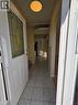 The entryway features a white door with decorative glass inserts, leading into a hallway with light-colored tile flooring and an overhead light fixture - 62 Richwill Road Unit# Upper, Hamilton, ON  - Indoor Photo Showing Other Room 