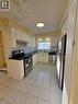 The kitchen features white cabinetry, dark countertops, a tiled backsplash, and stainless steel appliances, including a refrigerator, range, and dishwasher - 62 Richwill Road Unit# Upper, Hamilton, ON  - Indoor Photo Showing Kitchen 