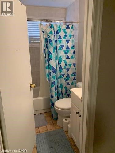 Bathroom with tiled flooring, a bathtub, and a window with blinds - 65 Cardill Crescent Unit# B, Waterloo, ON - Indoor Photo Showing Bathroom