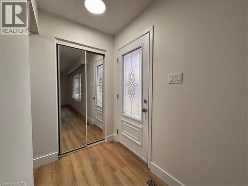 Entryway featuring light-toned flooring, a white entry door with decorative glass, and mirrored closet doors - 23 Arrowhead Crescent Unit# Upper, Kitchener, ON - Indoor Photo Showing Other Room