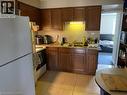 Kitchen featuring white appliances, light countertops, light tile patterned floors, and exhaust hood - 65 Cardill Crescent Unit# A, Waterloo, ON  - Indoor Photo Showing Kitchen 