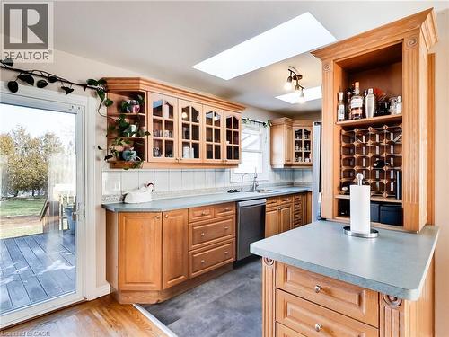 Kitchen featuring open shelves, a skylight, dishwasher, glass insert cabinets, and light countertops - 9183 Silver Street, Caistor Centre, ON - Indoor