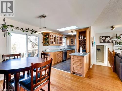 Kitchen with a skylight, glass insert cabinets, light wood-style flooring, dishwasher, and open shelves - 9183 Silver Street, Caistor Centre, ON - Indoor Photo Showing Dining Room