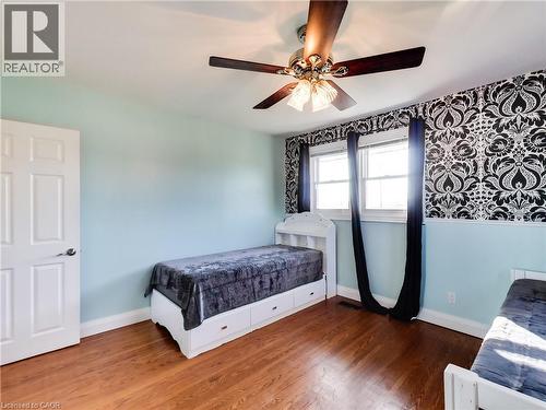 Bedroom with wood finished floors, ceiling fan, and wallpapered walls - 9183 Silver Street, Caistor Centre, ON - Indoor Photo Showing Bedroom